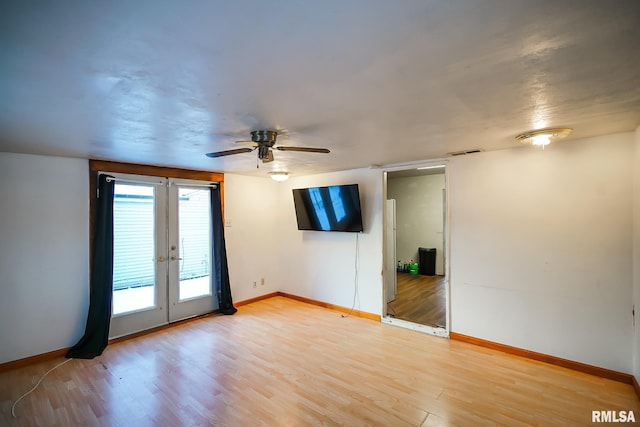 unfurnished room with visible vents, a ceiling fan, french doors, light wood-style floors, and baseboards