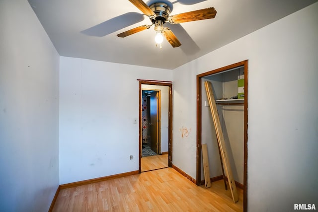 unfurnished bedroom featuring a ceiling fan, baseboards, a closet, and light wood-style flooring