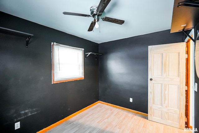 spare room with ceiling fan, baseboards, and wood finished floors