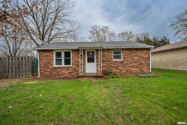 single story home with a front yard, fence, and brick siding