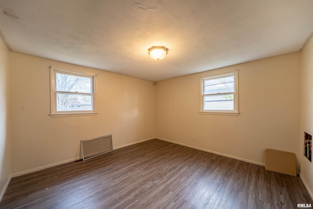 unfurnished room with wood finished floors, baseboards, and a wealth of natural light