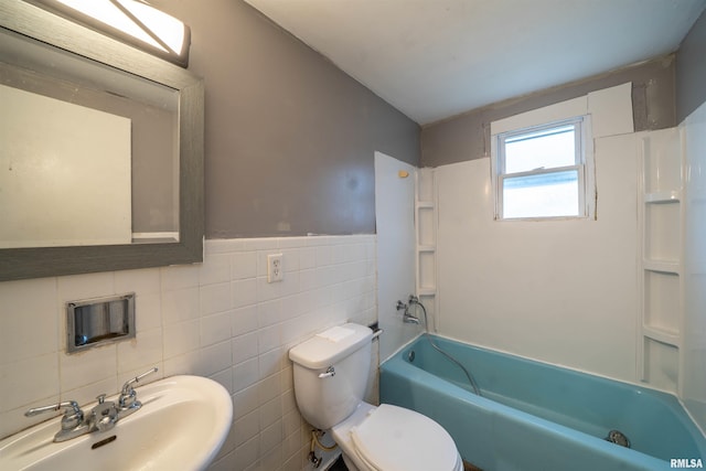 bathroom with shower / tub combination, toilet, a sink, wainscoting, and tile walls
