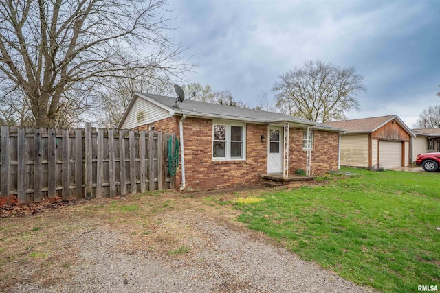 view of front of home with a garage, a front yard, brick siding, and fence