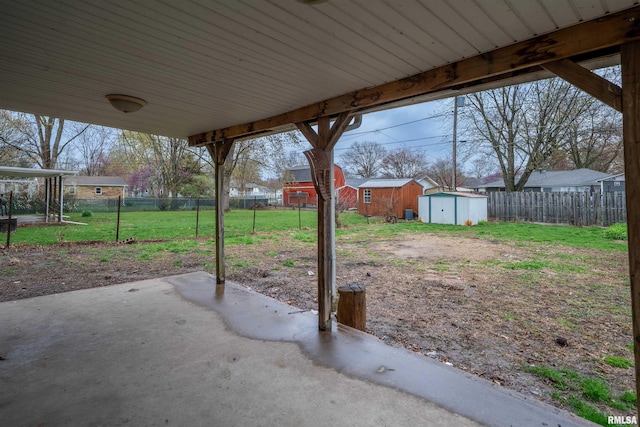 view of patio / terrace featuring a storage shed, a fenced backyard, and an outdoor structure