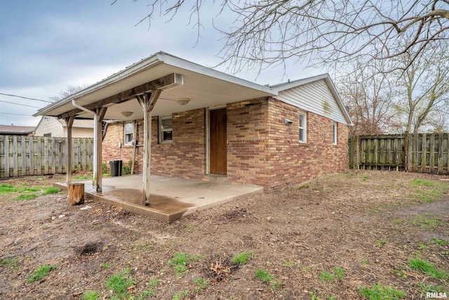back of house featuring a patio area, a fenced backyard, and brick siding