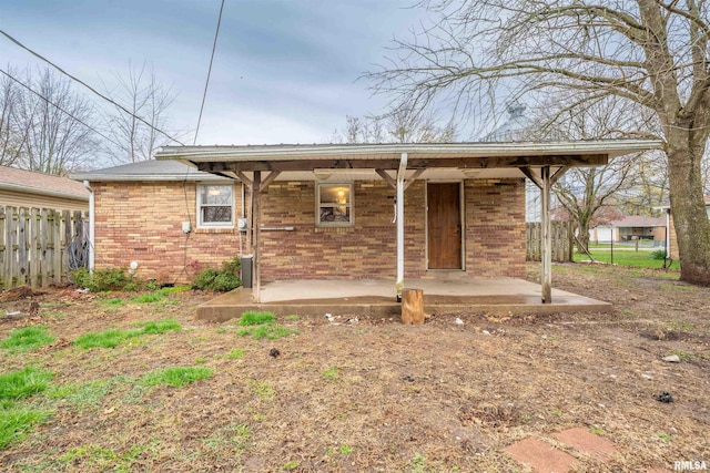 back of property featuring brick siding and fence