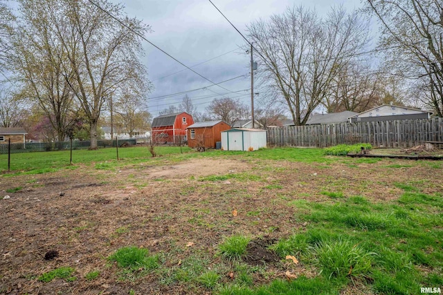 view of yard featuring an outbuilding, a fenced backyard, and a storage unit