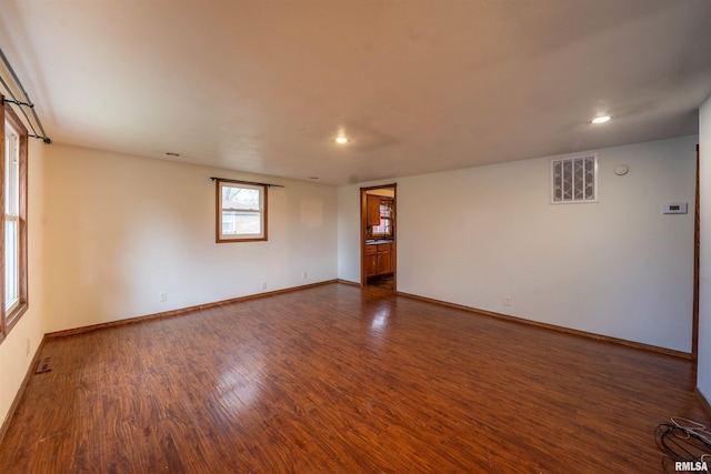 unfurnished room featuring baseboards, dark wood-style floors, visible vents, and recessed lighting