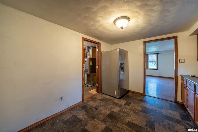 interior space with stone finish floor, baseboards, and a textured ceiling