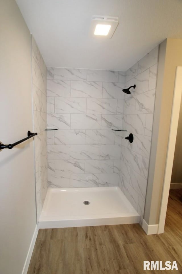 106 Samuel Ct, Washington, IL 61571 - bathroom featuring wood finished floors, a tile shower, and baseboards