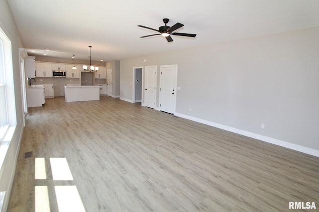 106 Samuel Ct, Washington, IL 61571 - unfurnished living room featuring a sink, light wood finished floors, baseboards, a ceiling fan, and recessed lighting