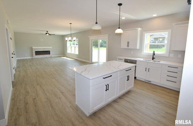 106 Samuel Ct, Washington, IL 61571 - kitchen featuring a sink, light wood-type flooring, recessed lighting, a fireplace, and a kitchen island