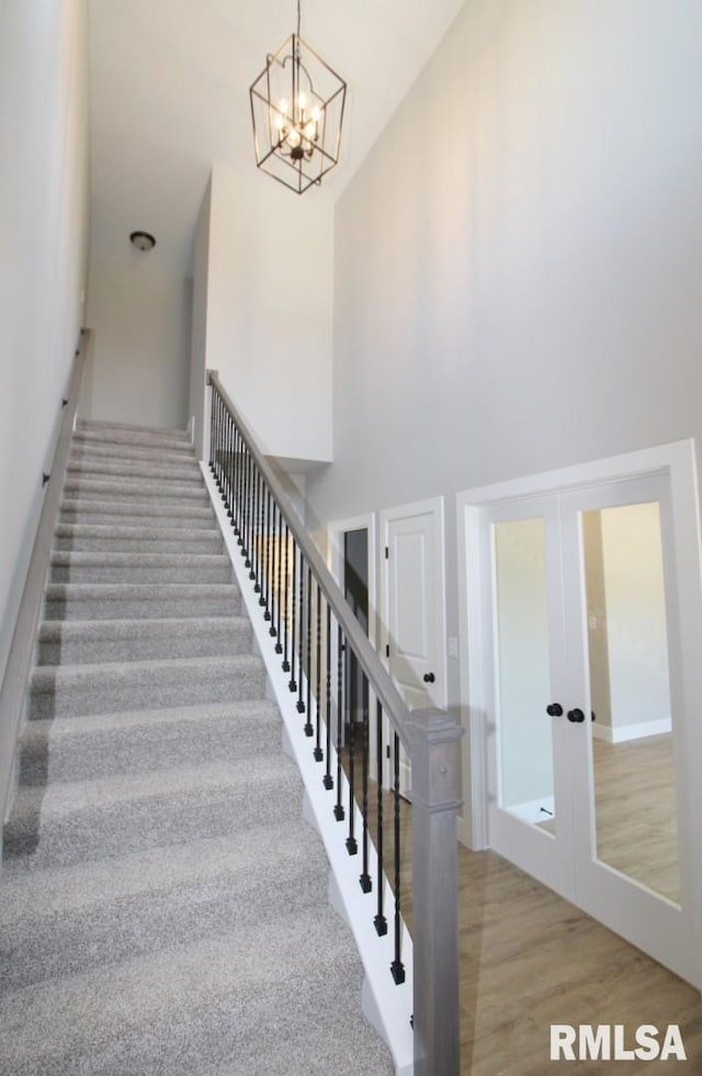 106 Samuel Ct, Washington, IL 61571 - staircase featuring a towering ceiling, french doors, a chandelier, and wood finished floors
