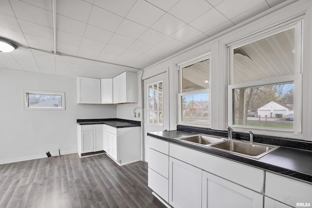 2330 S Airport Rd, Bartonville, IL 61607 - kitchen with white cabinets, baseboards, a sink, dark countertops, and dark wood-style floors
