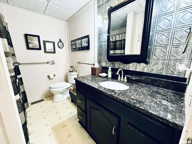 bathroom featuring toilet, vanity, curtained shower, and visible vents