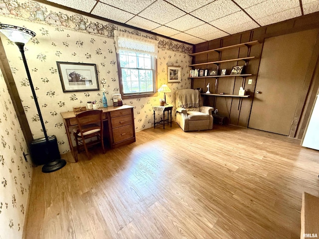 living area with light wood-type flooring and wallpapered walls