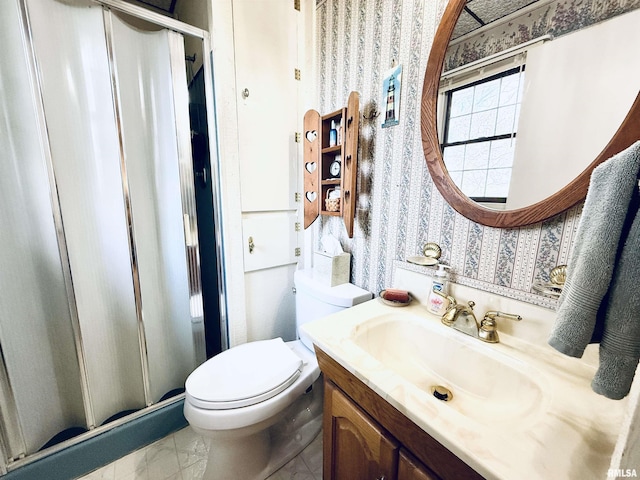 bathroom featuring wallpapered walls, a shower stall, toilet, and vanity