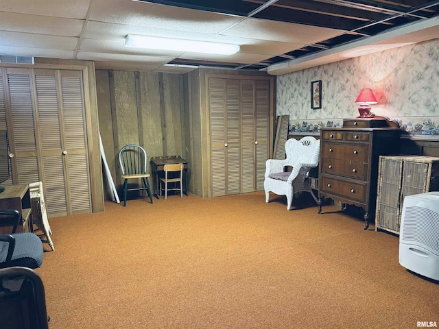 finished basement with wallpapered walls, visible vents, carpet, and a drop ceiling