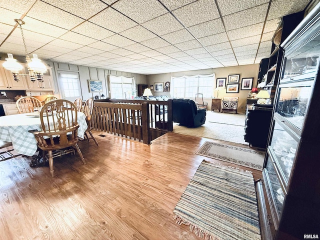 dining room featuring wood finished floors and a drop ceiling