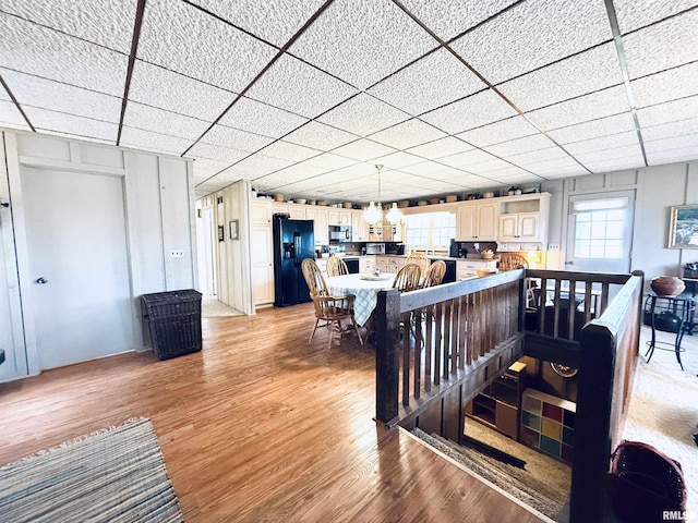 dining space featuring light wood-style flooring and a paneled ceiling
