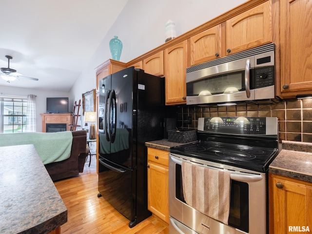 kitchen with backsplash, light wood-type flooring, lofted ceiling, and stainless steel appliances