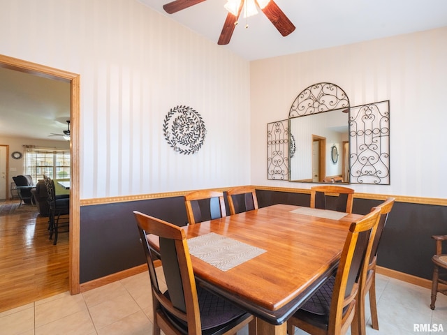 dining room with light tile patterned floors, a ceiling fan, and wallpapered walls