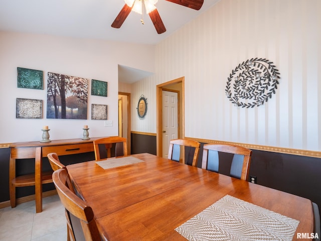 dining space featuring light tile patterned floors, ceiling fan, and wallpapered walls