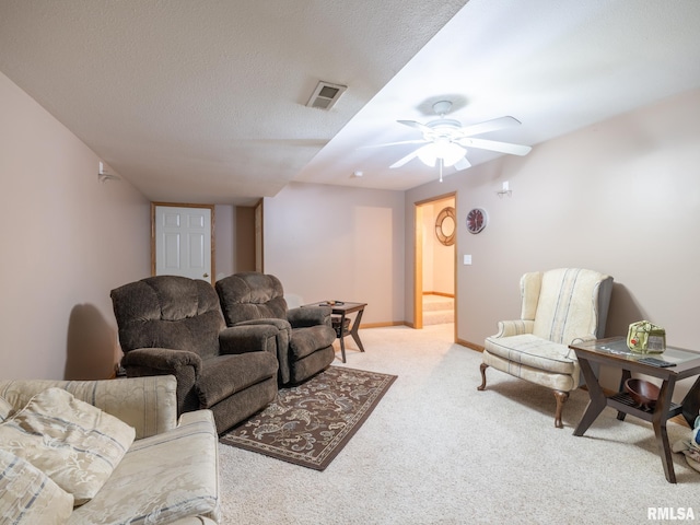 living room with visible vents, ceiling fan, light carpet, and baseboards