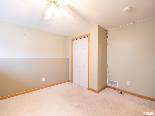 unfurnished bedroom with a closet, baseboards, a ceiling fan, visible vents, and carpet