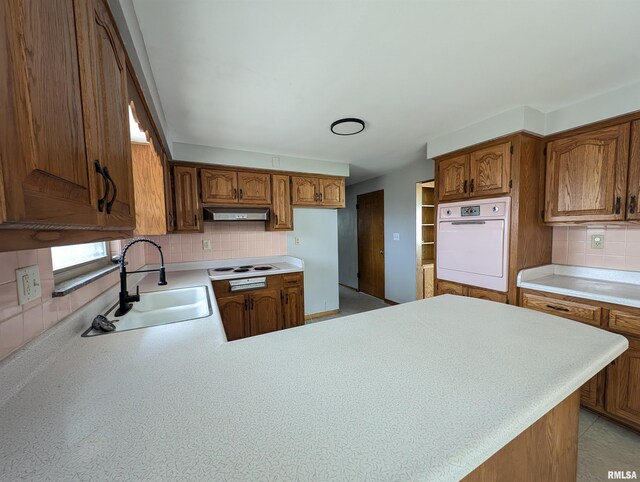 3720 Saint Michael Ave, Peoria, IL 61615 - kitchen with white appliances, under cabinet range hood, light countertops, a sink, and decorative backsplash