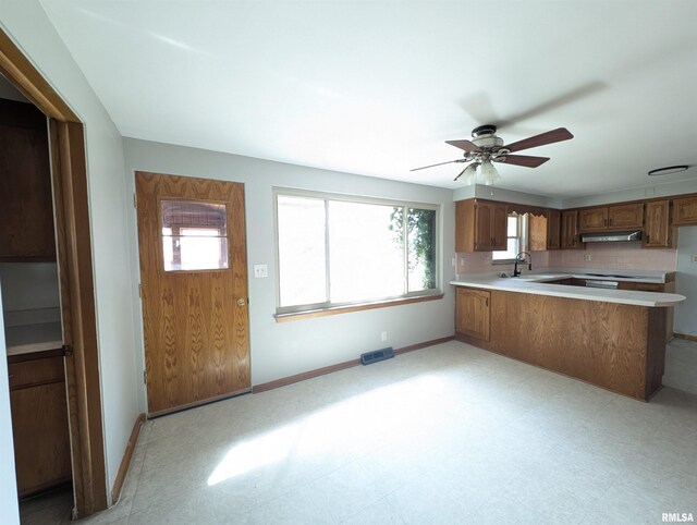 3720 Saint Michael Ave, Peoria, IL 61615 - kitchen featuring a peninsula, a sink, light countertops, and baseboards