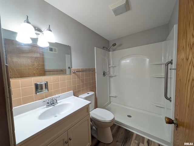 3720 Saint Michael Ave, Peoria, IL 61615 - bathroom featuring visible vents, tile walls, wood finished floors, and walk in shower