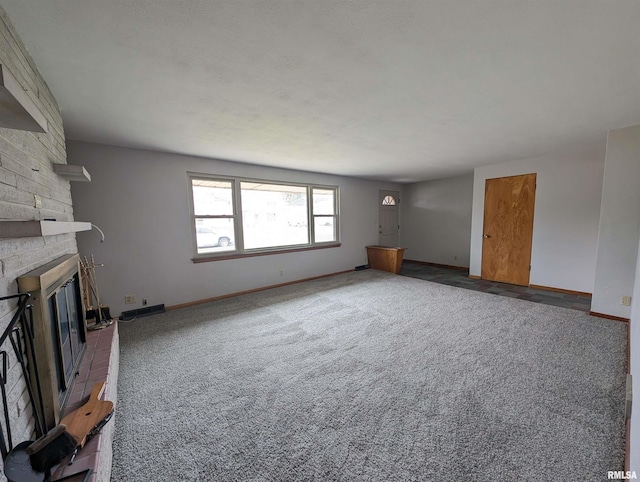 3720 Saint Michael Ave, Peoria, IL 61615 - unfurnished living room featuring visible vents, baseboards, a stone fireplace, and carpet floors