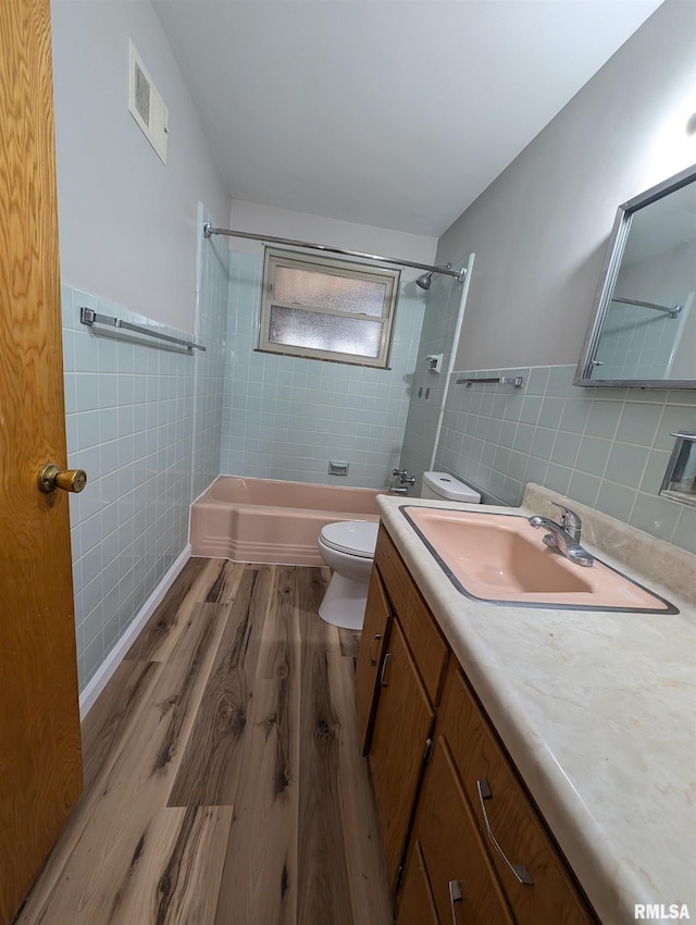 3720 Saint Michael Ave, Peoria, IL 61615 - bathroom with toilet, visible vents, bathtub / shower combination, tile walls, and wood finished floors