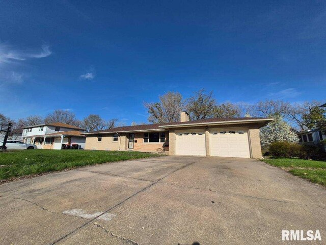 3720 Saint Michael Ave, Peoria, IL 61615 - ranch-style house with concrete driveway, a front lawn, a chimney, and an attached garage