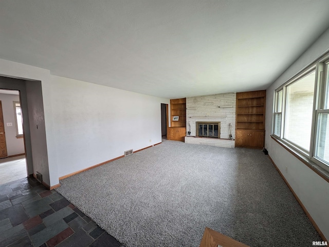 3720 Saint Michael Ave, Peoria, IL 61615 - unfurnished living room featuring baseboards, built in shelves, visible vents, and a wealth of natural light