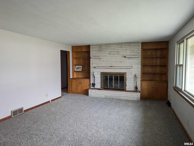 3720 Saint Michael Ave, Peoria, IL 61615 - unfurnished living room with baseboards, built in features, carpet floors, a brick fireplace, and visible vents
