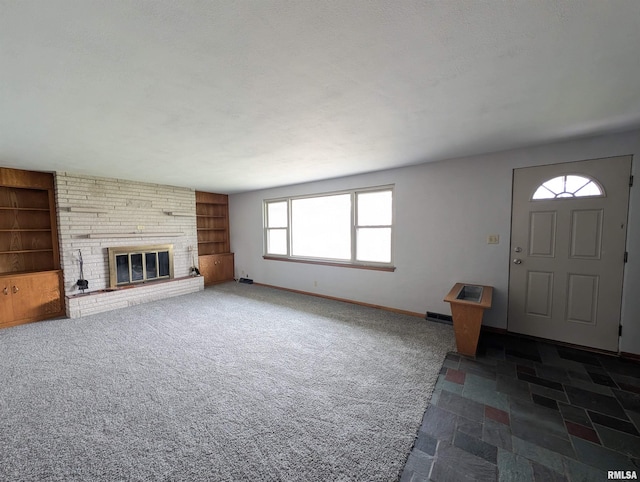 3720 Saint Michael Ave, Peoria, IL 61615 - unfurnished living room with dark carpet, built in features, baseboards, and a brick fireplace