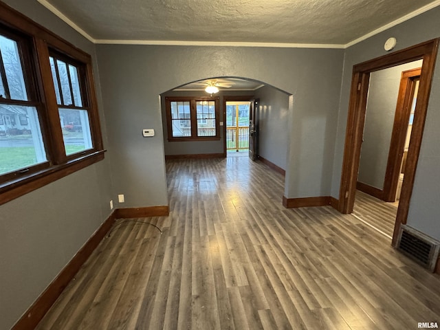 1017 W Brons Ave, Peoria, IL 61604 - empty room with arched walkways, ornamental molding, visible vents, and plenty of natural light