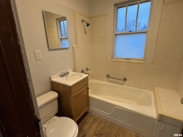 1017 W Brons Ave, Peoria, IL 61604 - bathroom with washtub / shower combination, toilet, vanity, and wood finished floors
