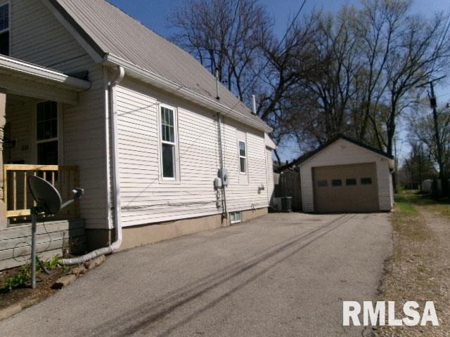view of side of property featuring an outbuilding, driveway, and a detached garage