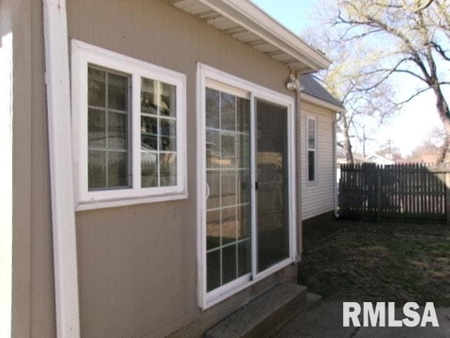 view of property exterior with stucco siding and fence