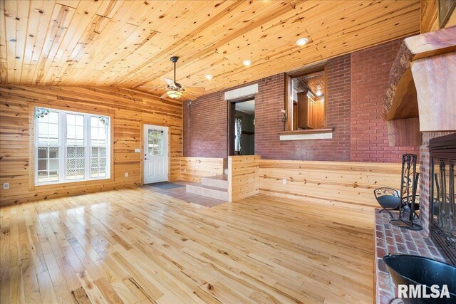 unfurnished dining area with wooden walls, wood-type flooring, wooden ceiling, and lofted ceiling