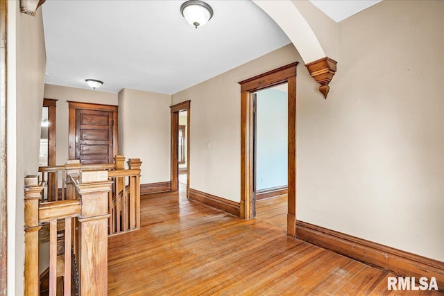 interior space with light wood-style flooring, baseboards, and an upstairs landing