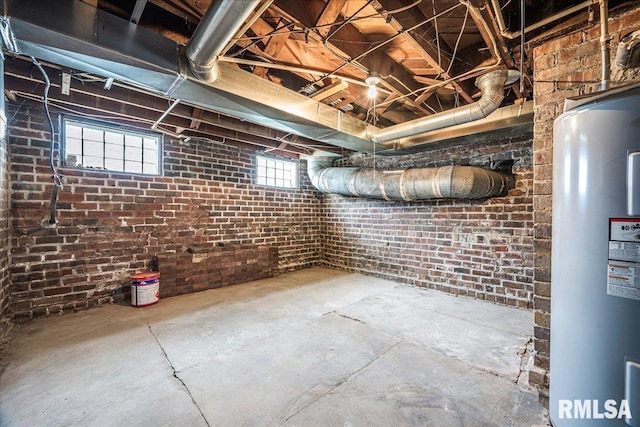 below grade area featuring brick wall and water heater