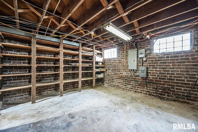 basement featuring brick wall and electric panel