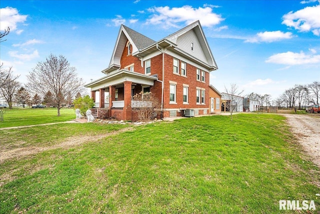 view of side of home with brick siding, central AC unit, and a lawn