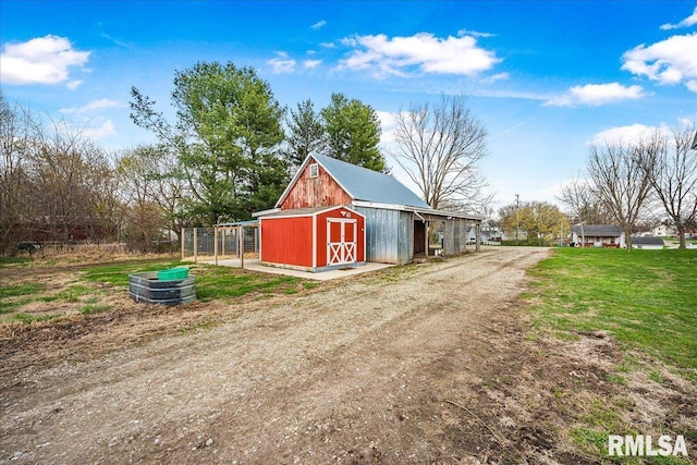 view of outbuilding with driveway and an outbuilding