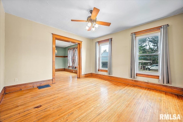 empty room with visible vents, baseboards, ceiling fan, and light wood-style floors