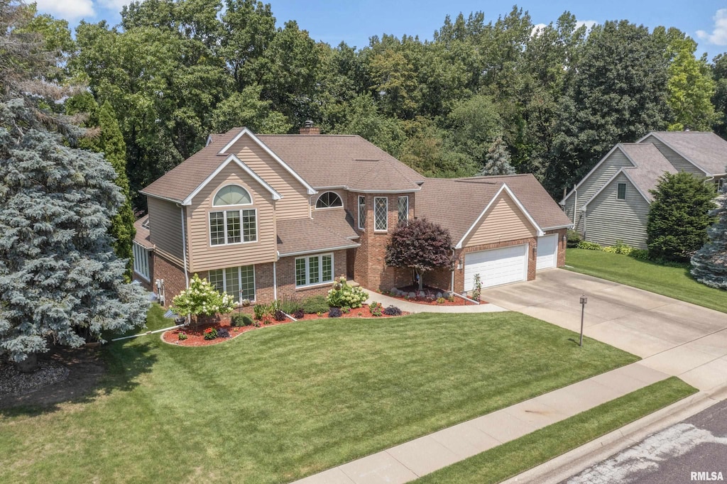 11223 N Oak Trail Dr, Peoria, IL 61615 - view of front of home featuring a chimney, driveway, an attached garage, a front lawn, and brick siding